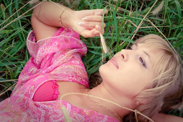 Jeune femme se relaxant sur une prairie verte — Photo