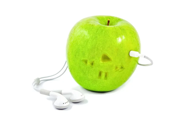 Green apple in which headphones — Stock Photo, Image
