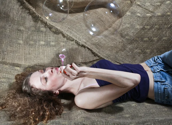 La chica infla burbujas de jabón — Foto de Stock