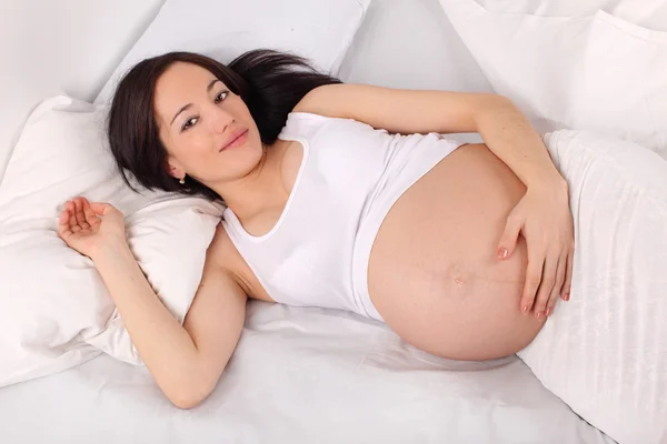 Mujer embarazada en la cama — Foto de Stock