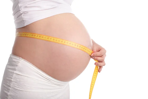 Femme enceinte mesurant une taille — Photo