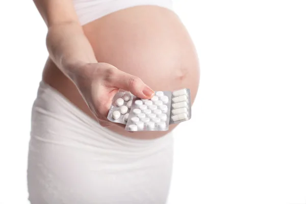 Mulher grávida segurando pílulas — Fotografia de Stock