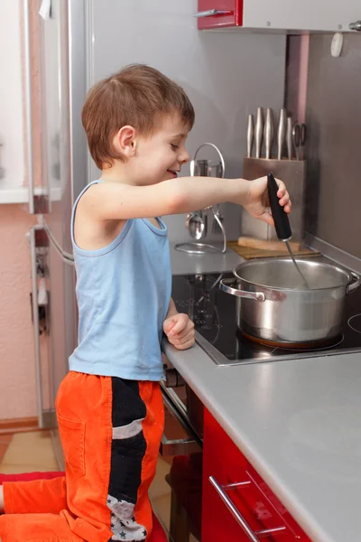 Barn matlagning gröt — Stockfoto
