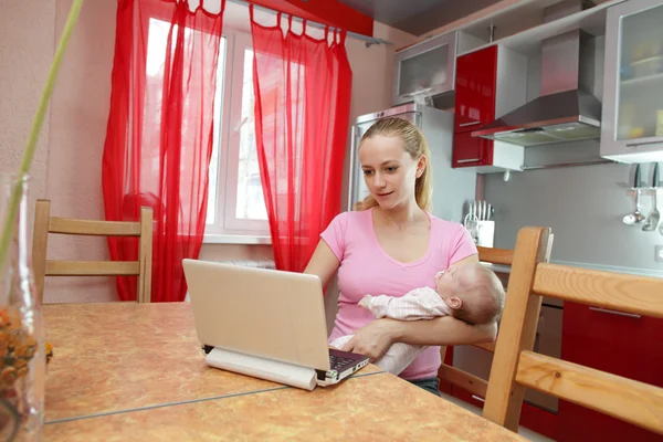 Młoda matka w kuchni z laptopem — Zdjęcie stockowe