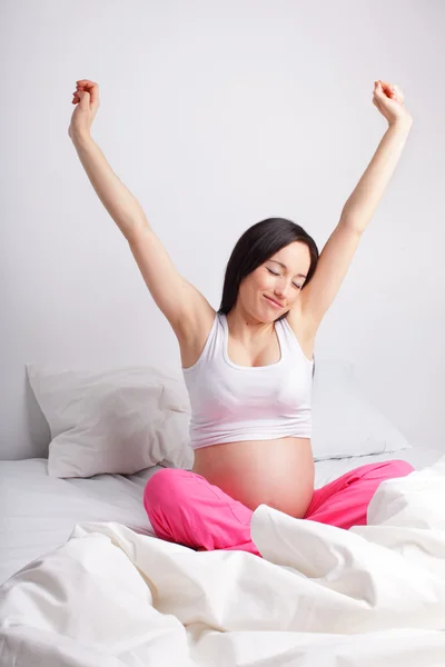 Gravid kvinna i en säng — Stockfoto
