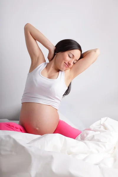 Femme enceinte dans un lit — Photo