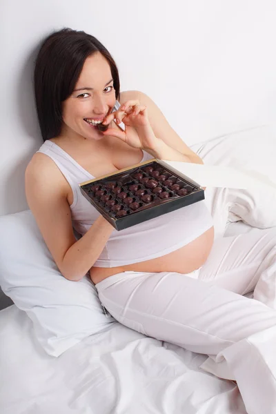 Zwangere vrouw eet snoepjes — Stockfoto
