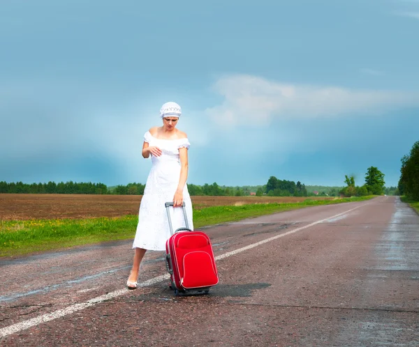 Mädchen im weißen Kleid mit Koffer — Stockfoto
