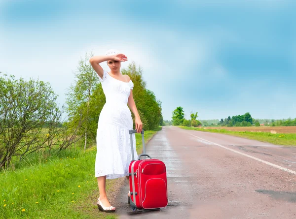Flicka i vit klänning med resväska — Stockfoto