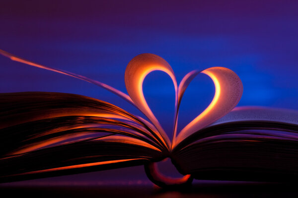 Open book in red heart shape on blue background
