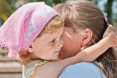 Little girl hugging her mother's neck, smiling clipart