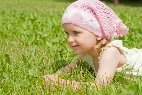 Ένα μικρό κορίτσι που βρίσκεται σε έναν πράσινο χορτοτάπητα — Φωτογραφία Αρχείου
