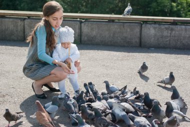 Anne ve kızı güvercin besleme