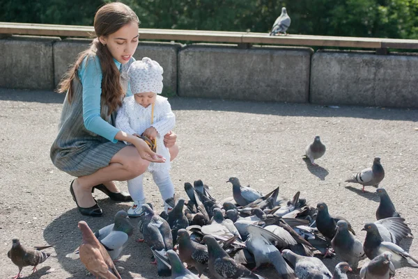 Mamma e figlia alimentazione piccioni — Foto Stock