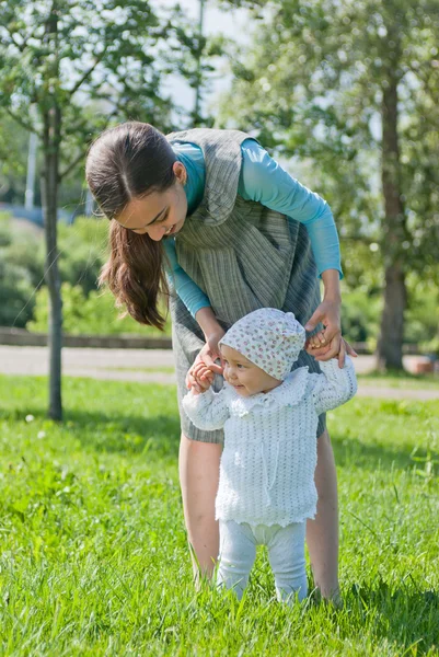 Mom teaches her little daughter to walk, hands — Stock Photo, Image