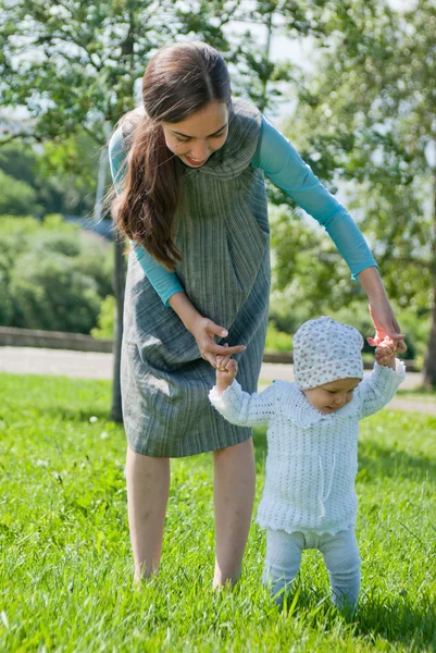 Mom teaches her little daughter to walk, hands — Stok fotoğraf