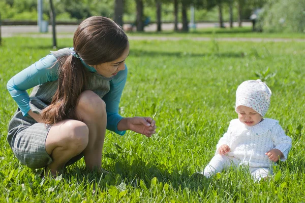 公園の芝生で泣いている娘を慰める母親 — ストック写真