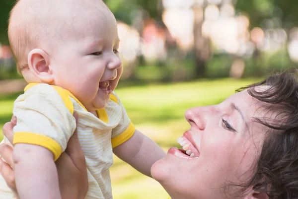 Baby and mother look at each other, smiling — Stock Photo, Image