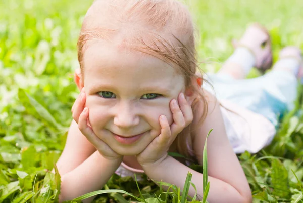 Meisje liggen op het gras, glimlachend — Stockfoto