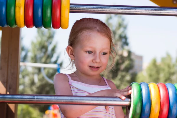 Malá holčička hraje s kroužky v parku — Stock fotografie