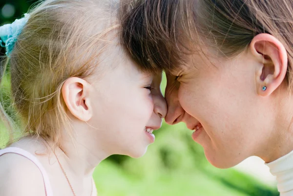 Mother and daughter hugged each other with their noses — Stock Photo, Image