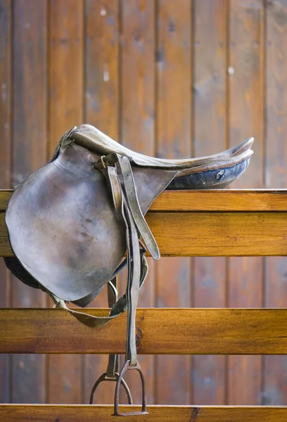 Saddle on a wooden railing — Stock Photo, Image