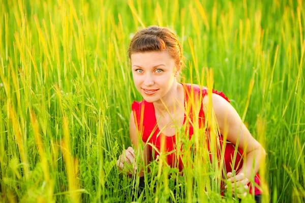 Menina bonita jovem senta-se no prado — Fotografia de Stock
