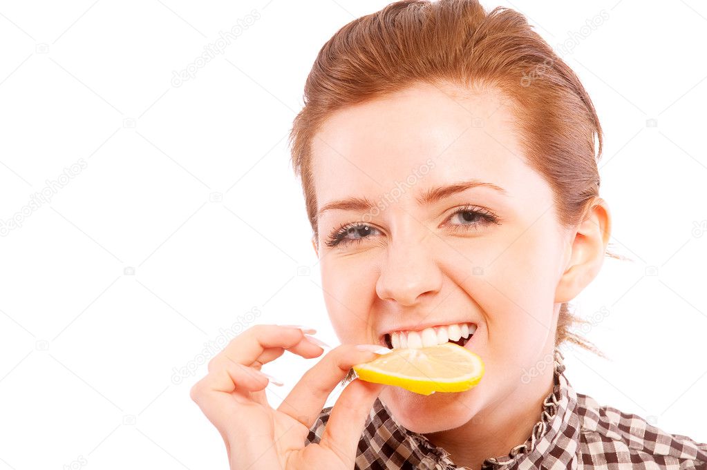 Young woman eating sour lemon