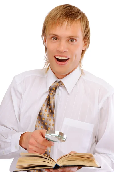 Young man with magnifier is surprised by read bo — Stock Photo, Image
