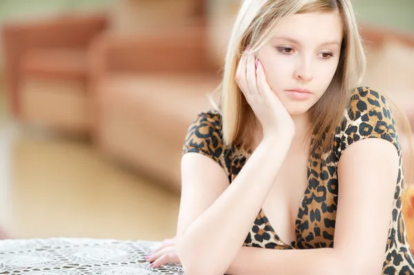 Smutna dziewczyna siedzi przy stole — Zdjęcie stockowe
