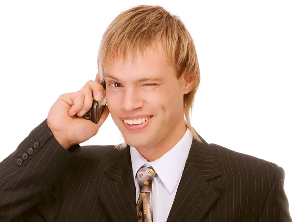 Young businessman winks and speaks by phone — Stock Photo, Image