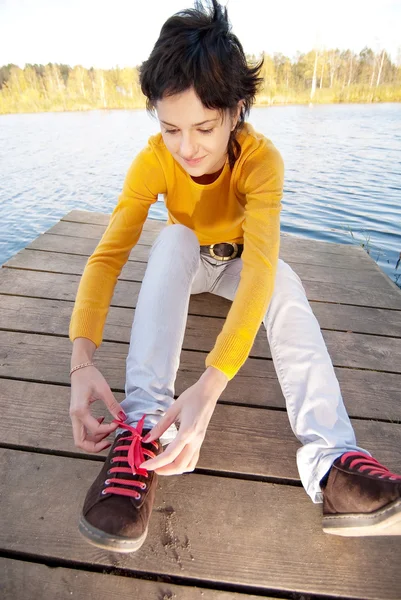 Девушка застегивает шнурки на спортивной обуви — стоковое фото
