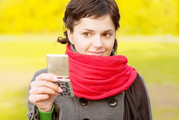 Girl with red scarf looks in mirror — Stock Photo, Image