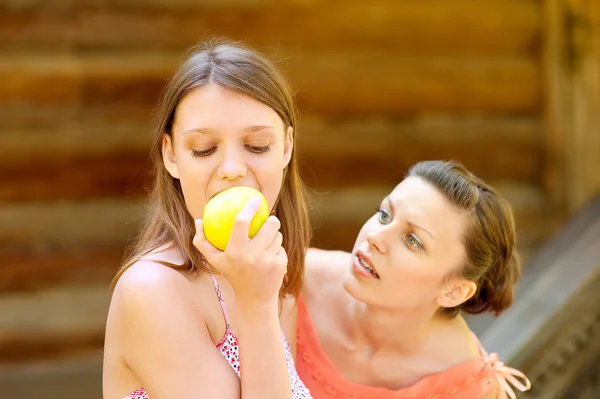 Menina bonita dando uma mordida de uma maçã — Fotografia de Stock