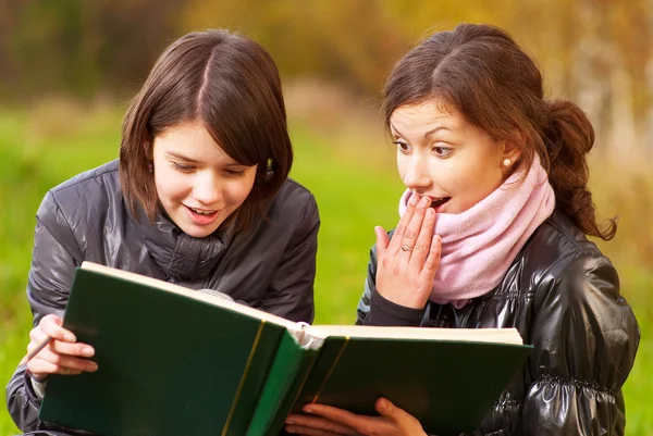 Две привлекательные девушки читают книгу — стоковое фото