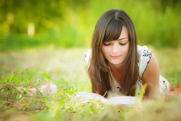 Όμορφη κοπέλα ψέματα και διαβάζει — Φωτογραφία Αρχείου