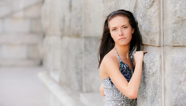 Hermosa chica sobre muro de piedra — Foto de Stock
