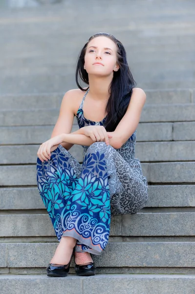 Menina bonita jovem senta-se em passos — Fotografia de Stock