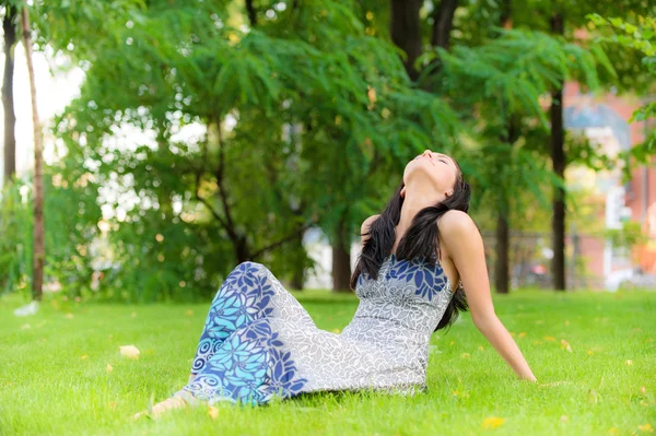 Mladá dívka má odpočinek na trávníku — Stock fotografie