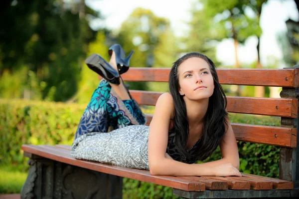 Vacker flicka ligger i park — Stockfoto