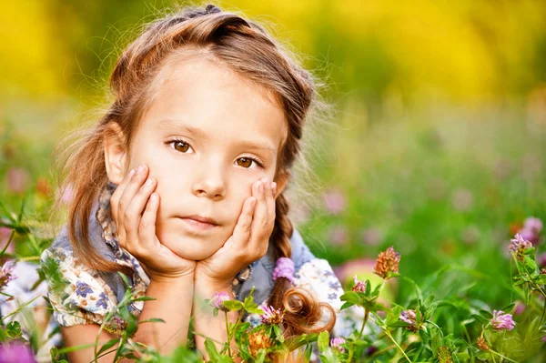 Маленькая девочка лежит на лужайке — стоковое фото