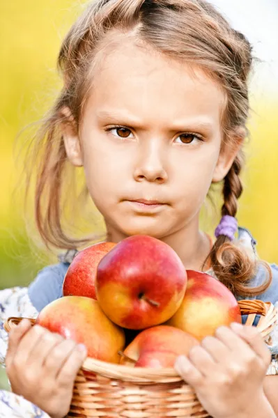 Маленька дівчинка з кошиком з яблуками — стокове фото