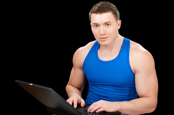 Sterke sportman werkt op laptop — Stockfoto