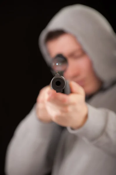 Sniper in hood aims at rifle — Stock Photo, Image