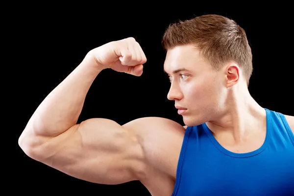 Poderoso construtor de corpo mostra bíceps — Fotografia de Stock