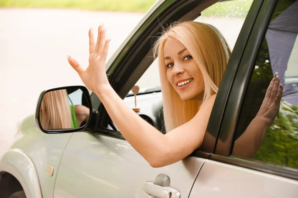 Driver-woman of car waves back — Stock Photo, Image