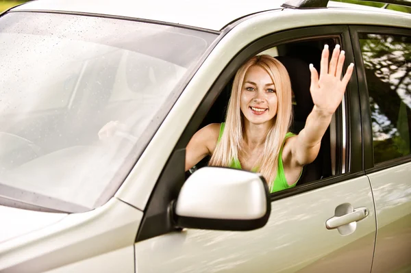 Женщина-водитель автомобиля размахивает рукой — стоковое фото