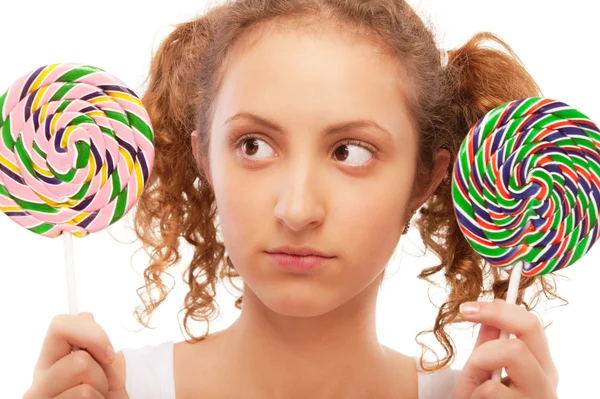 Beautiful girl chooses from two sugar candies — Stock Photo, Image