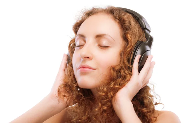 Όμορφο κορίτσι σγουρά ακούει μουσική μέσω αυτί-τηλέφωνα — Φωτογραφία Αρχείου
