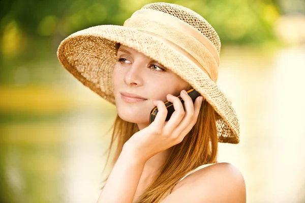 Meisje in stro hoed met telefoon — Stockfoto